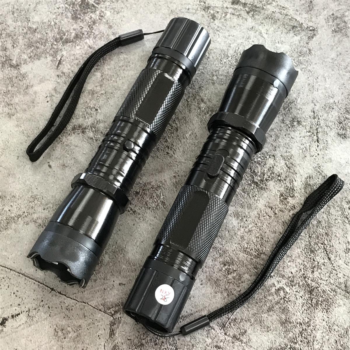 Two black 1101 flashlight stun guns angled showing side profile and grip texture