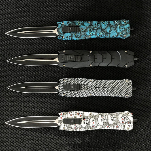 Four backpack EDC knives with black skull blue and gray handles in a row