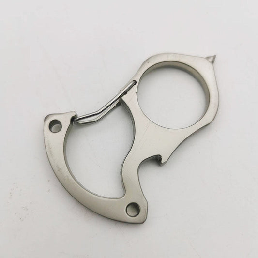 Bare steel version of the carabiner keychain tool on a white surface, showing the spring gate, round finger hole, bottle opener notch, countersunk handle holes and pointed tip