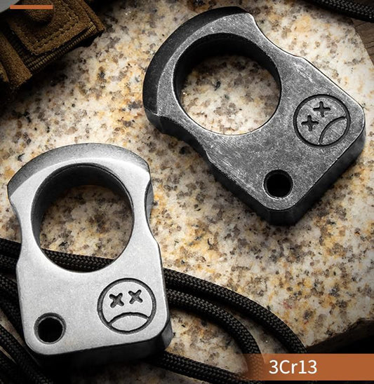 Gray single-hole knuckle weight held in a gloved hand showing the stone washed finish and the corner hole