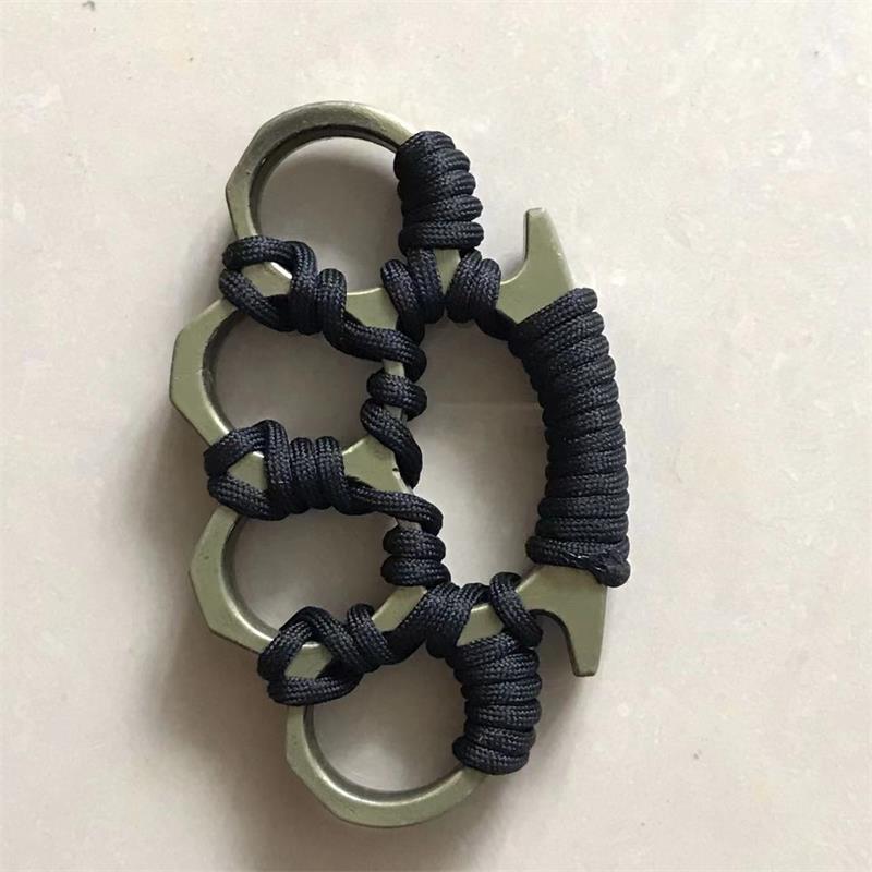 Flat view of the woven knuckle duster with a pale metallic frame and black umbrella rope wrapping on a plain background