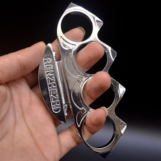 Silver knuckle duster worn on the fingers showing the round holes and engraved face