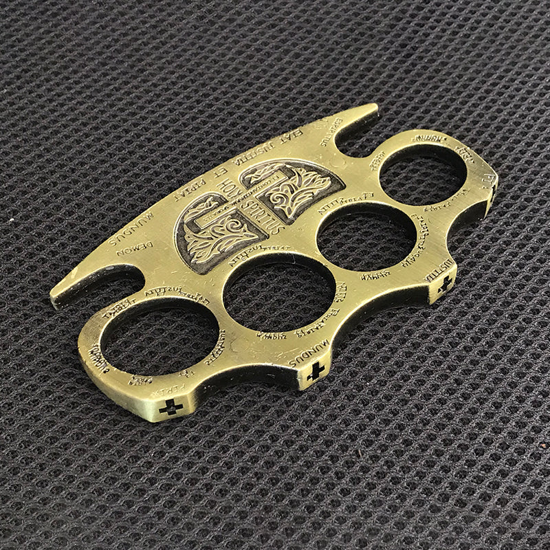 Golden zinc alloy knuckle duster on a black mat with the frame thickness shown from a low angle