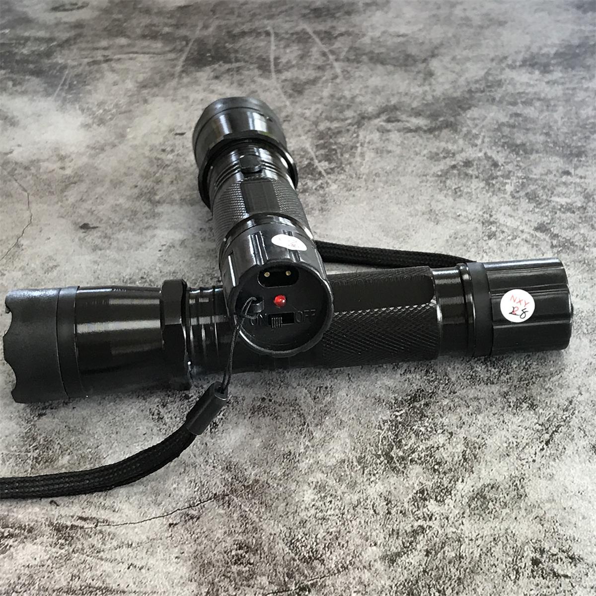 Close-up of charging port and power switch on black 1101 flashlight stun gun