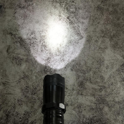 Black 1101 flashlight stun gun shining bright white LED beam on concrete floor