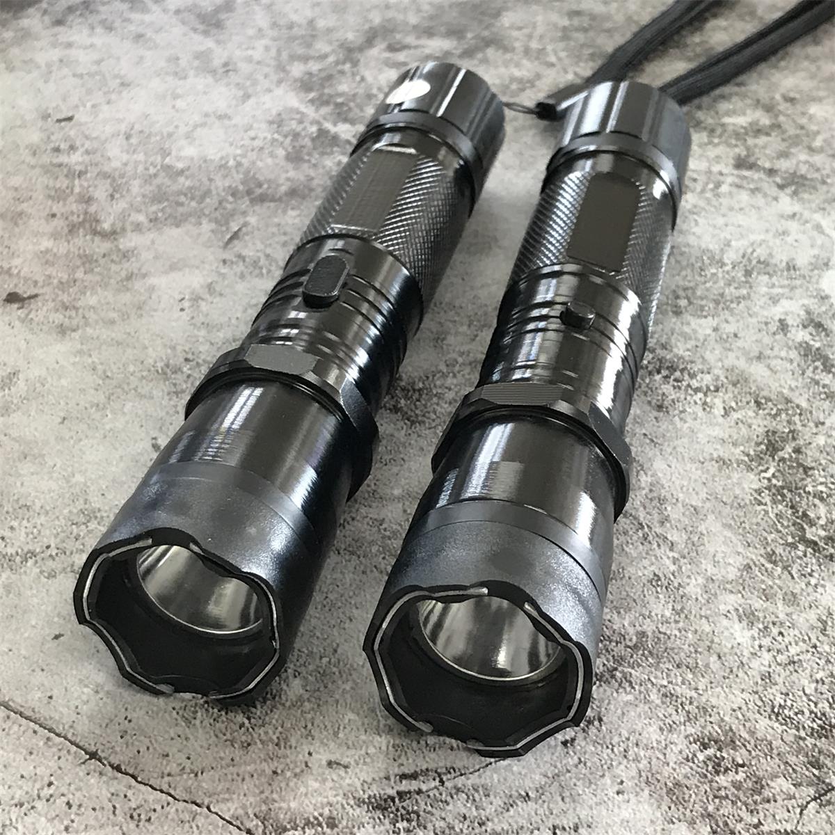 Close-up front view of two black 1101 stun gun flashlights with scalloped bezels and LED reflectors