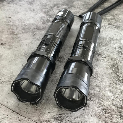 Close-up front view of two black 1101 stun gun flashlights with scalloped bezels and LED reflectors