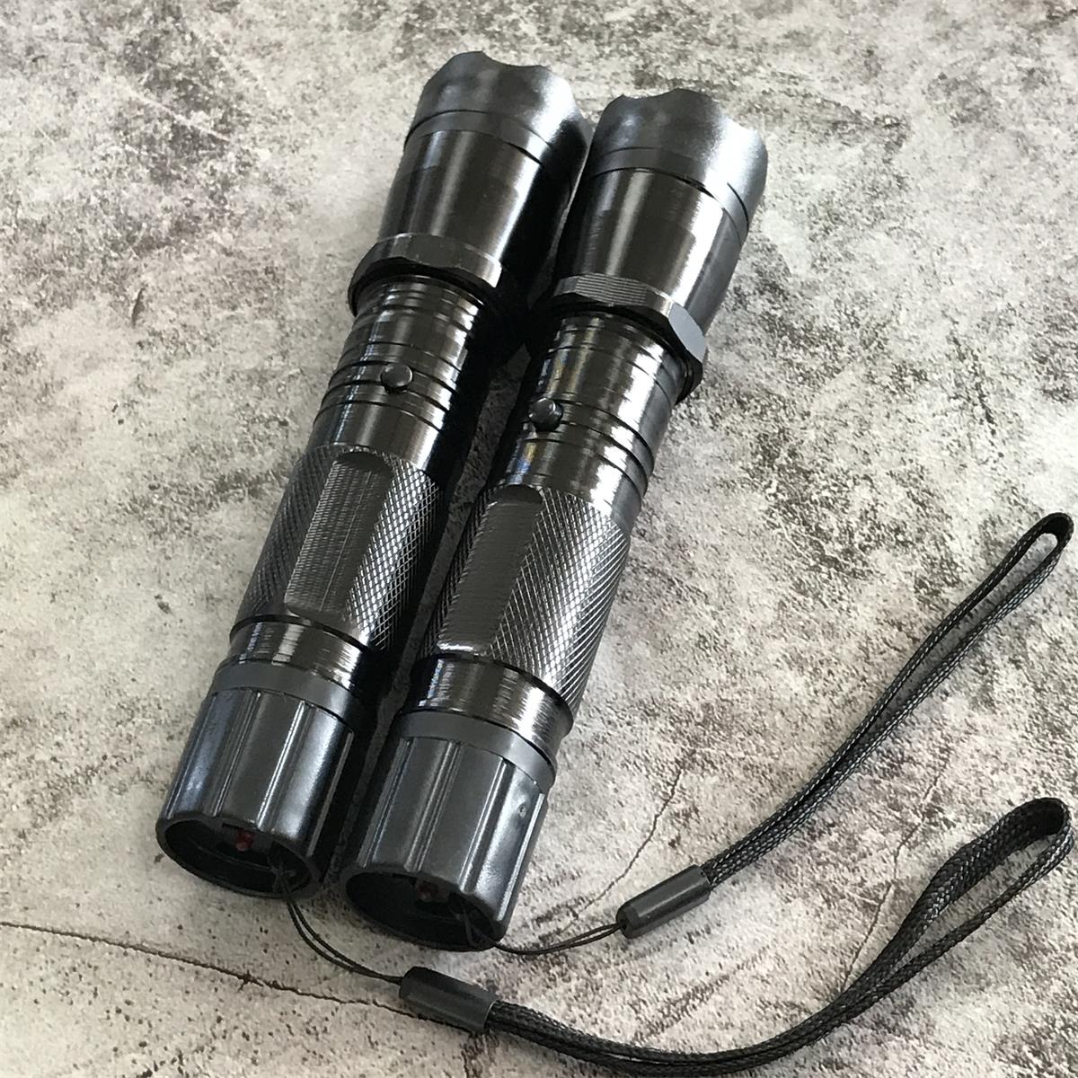 Two black 1101 flashlight stun guns from above showing rear charging ends and wrist straps