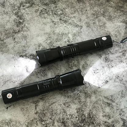 Top-down view of two black 1101 stun gun flashlights with beams shining on concrete surface