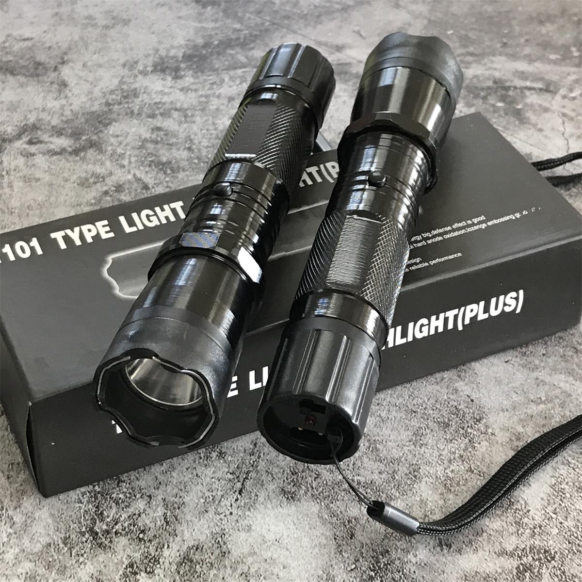Two black 1101 flashlight stun guns on product box, side by side showing textured grip and wrist strap