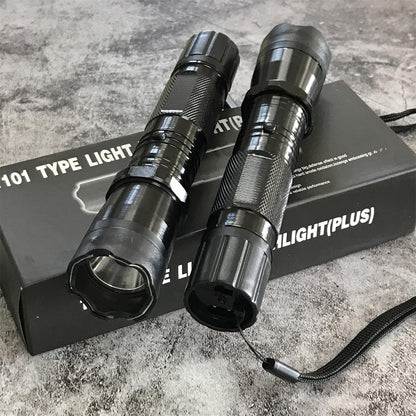Two black 1101 flashlight stun guns on product box, side by side showing textured grip and wrist strap