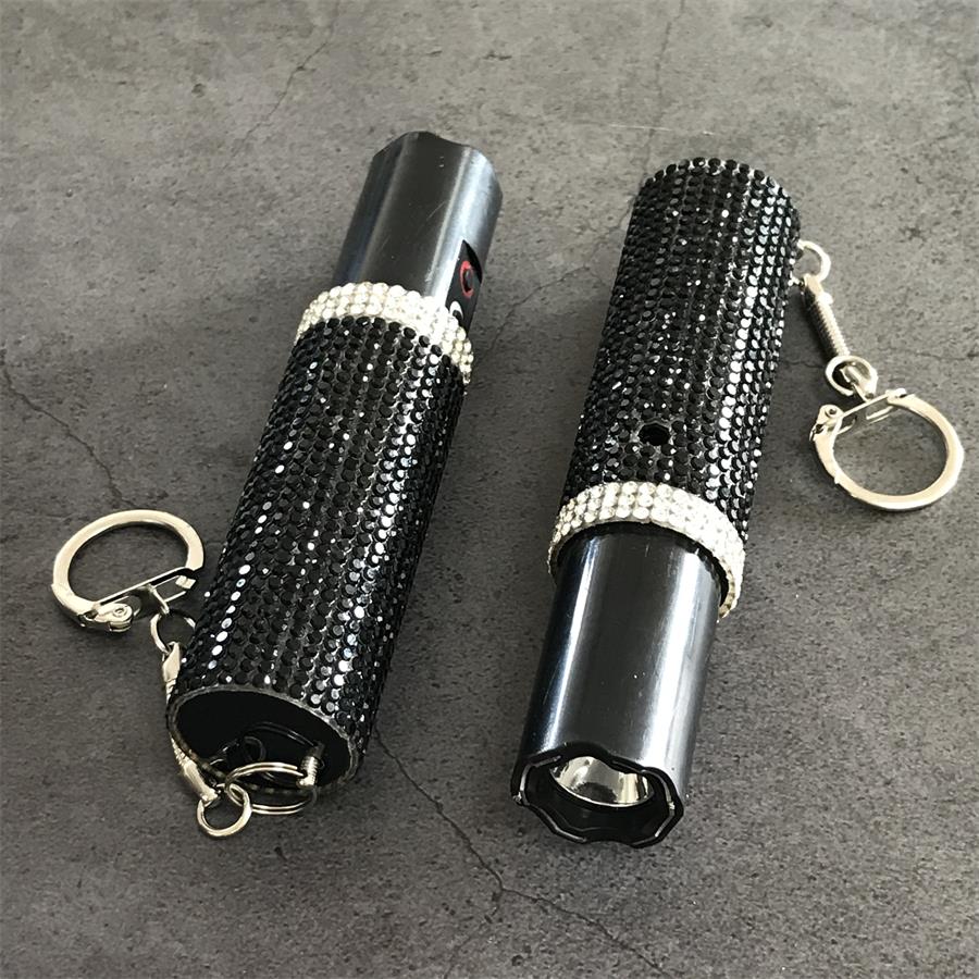 Two black rhinestone mini stun guns side by side, one with cap on and one with cap off