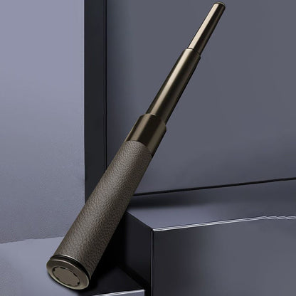 Extended baton with leather-textured handle leaning against dark geometric backdrop