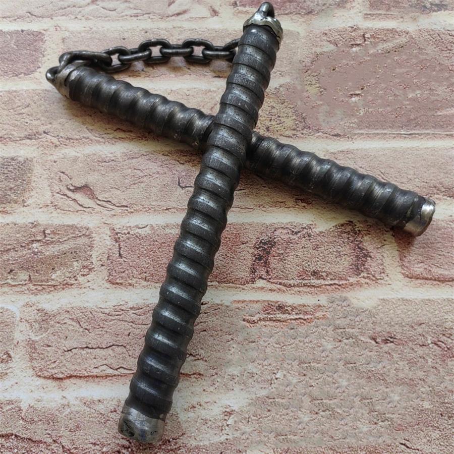 Two black chain baton handles crossed on brick wall with metal connector chain