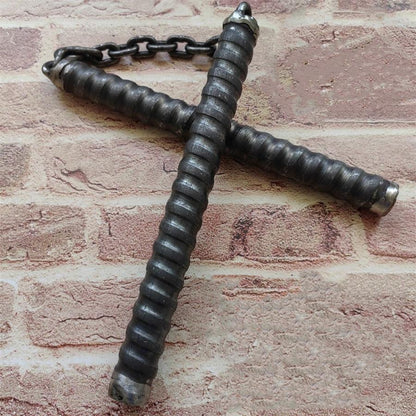 Two black chain baton handles crossed on brick wall with metal connector chain