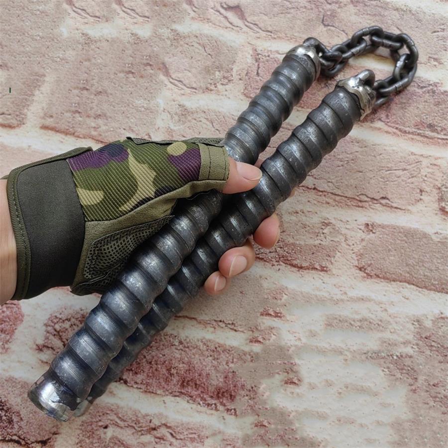 Gloved hand holding two black chain baton handles showing worn metal tips