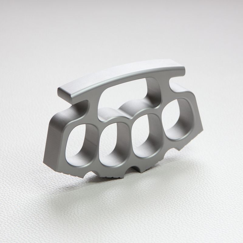 Silver knuckle duster standing upright on white background, palm-side view.