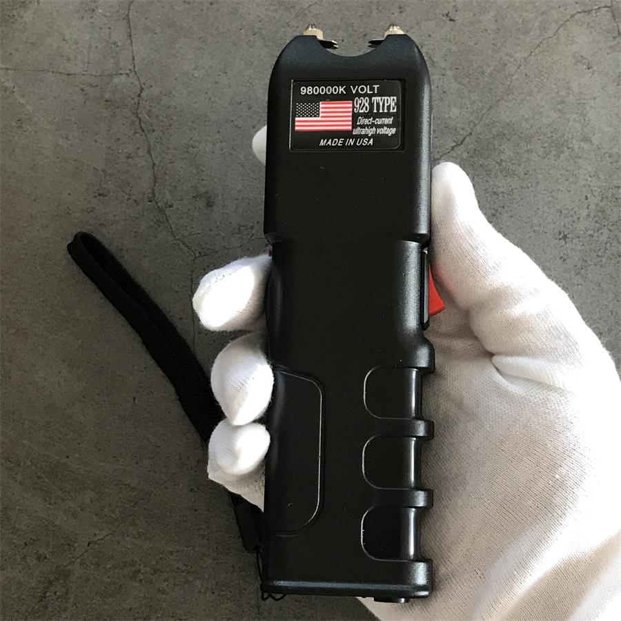 980000K 928 device held in a gloved hand showing textured grip