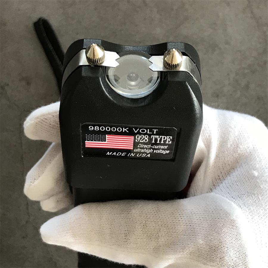 Close-up top of 980000K 928 device held in a gloved hand