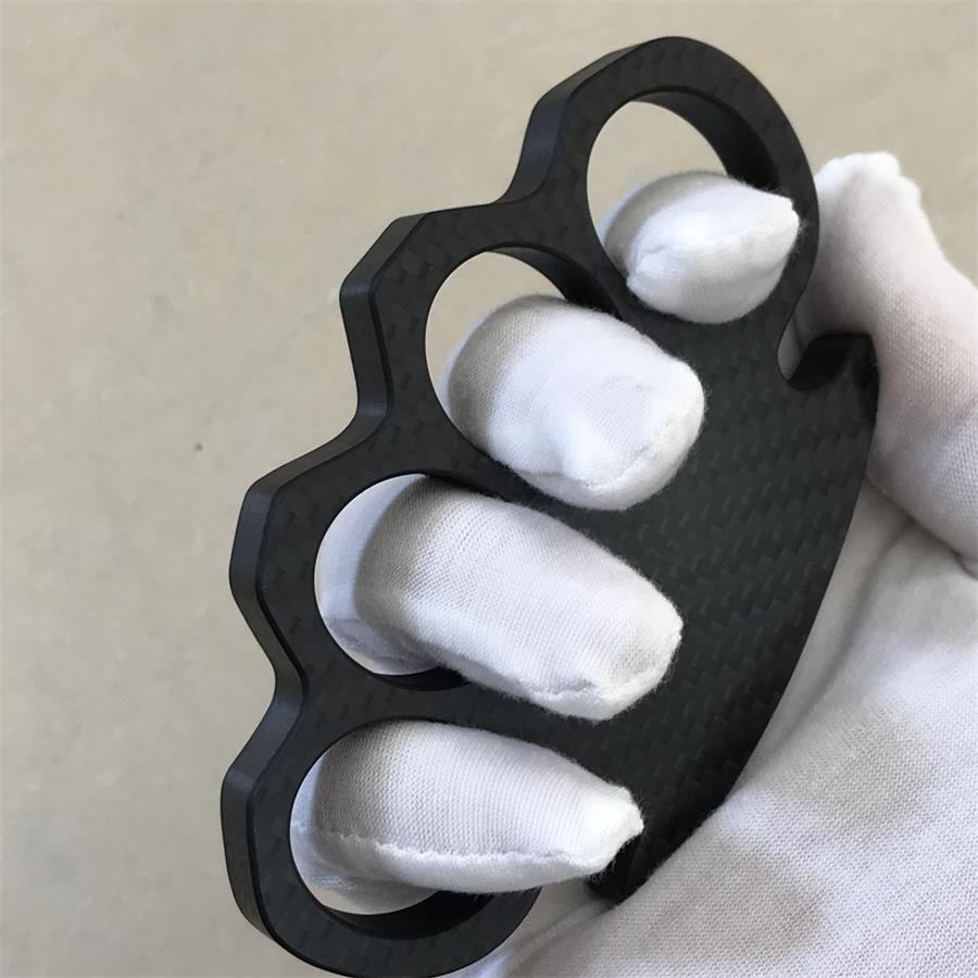 Gloved hand holds Classic Carbon Fiber Knuckle Duster