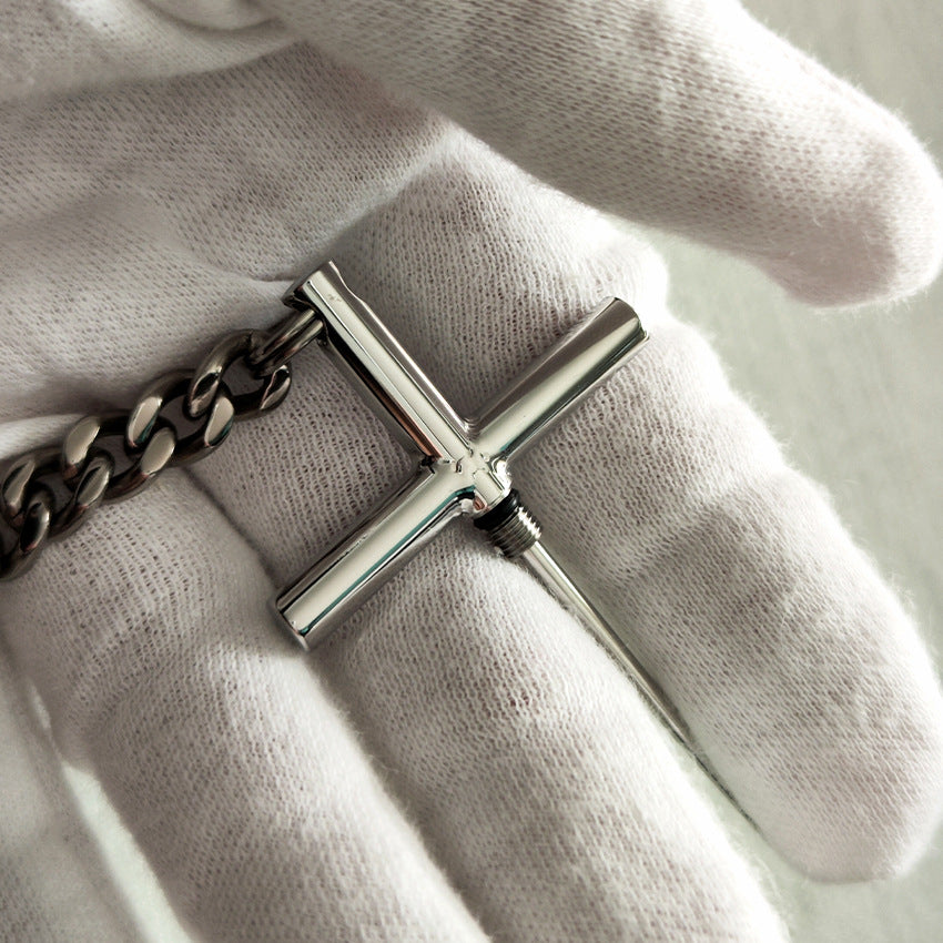 Close-up of the 304 steel cross toothpick with titanium chain in a white-gloved hand.
