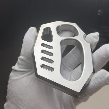 Close-up of the mirror polished two-finger knuckle duster with rope holes and machined slots in a gloved hand.