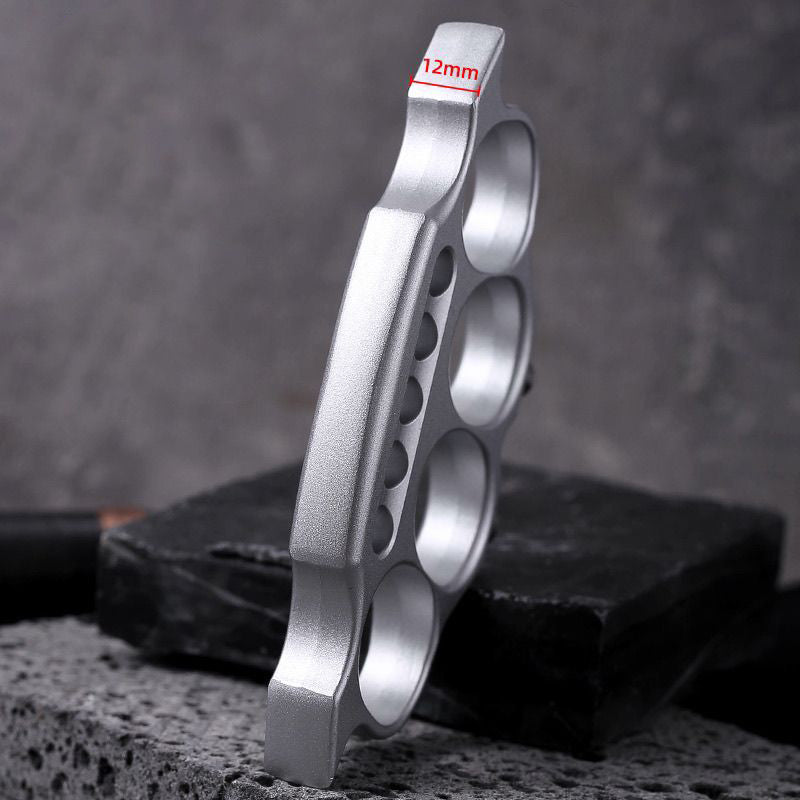 Zinc alloy knuckle duster standing upright on wood