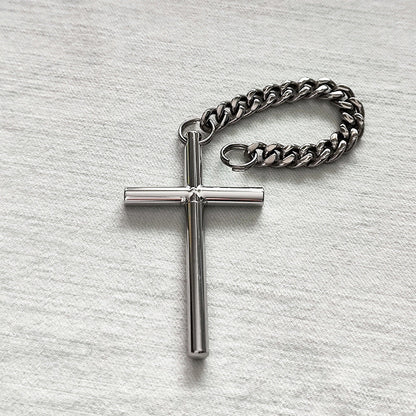 The 304 steel cross toothpick and pure titanium chain laid flat on a light textured surface.