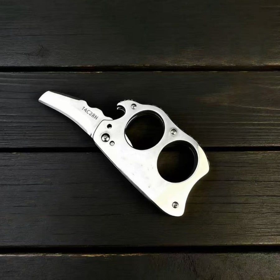 Mini Knuckle Knife lying flat on wood table	
