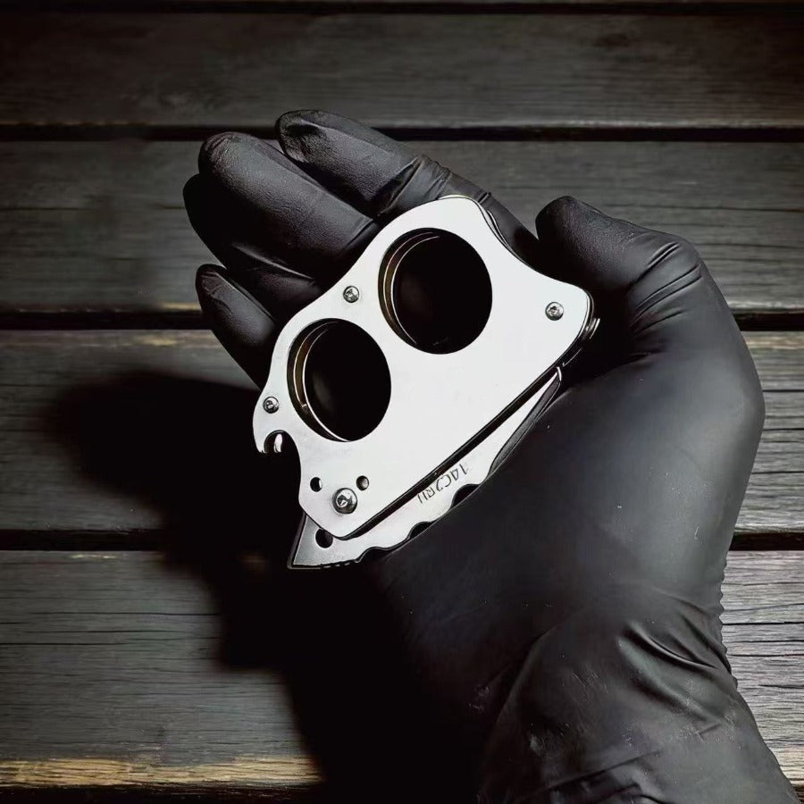 Black gloved hand holding Mini Knuckle Knife