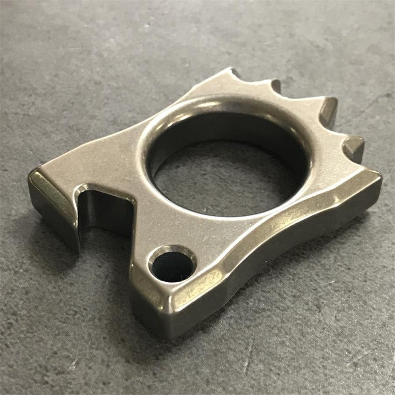 Titanium Knuckle Duster positioned lying on rough stone