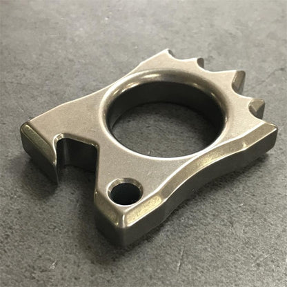 Titanium Knuckle Duster positioned lying on rough stone