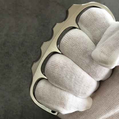 Titanium knuckle duster held in gloved hand
