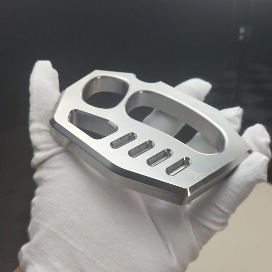 Mirror polished 304 stainless steel two-finger rope hole knuckle duster held in a white-gloved hand, angled view.