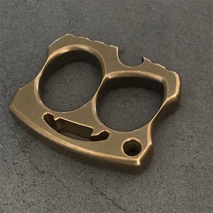 Aged brass two-hole knuckle with darker finish and opener slot visible