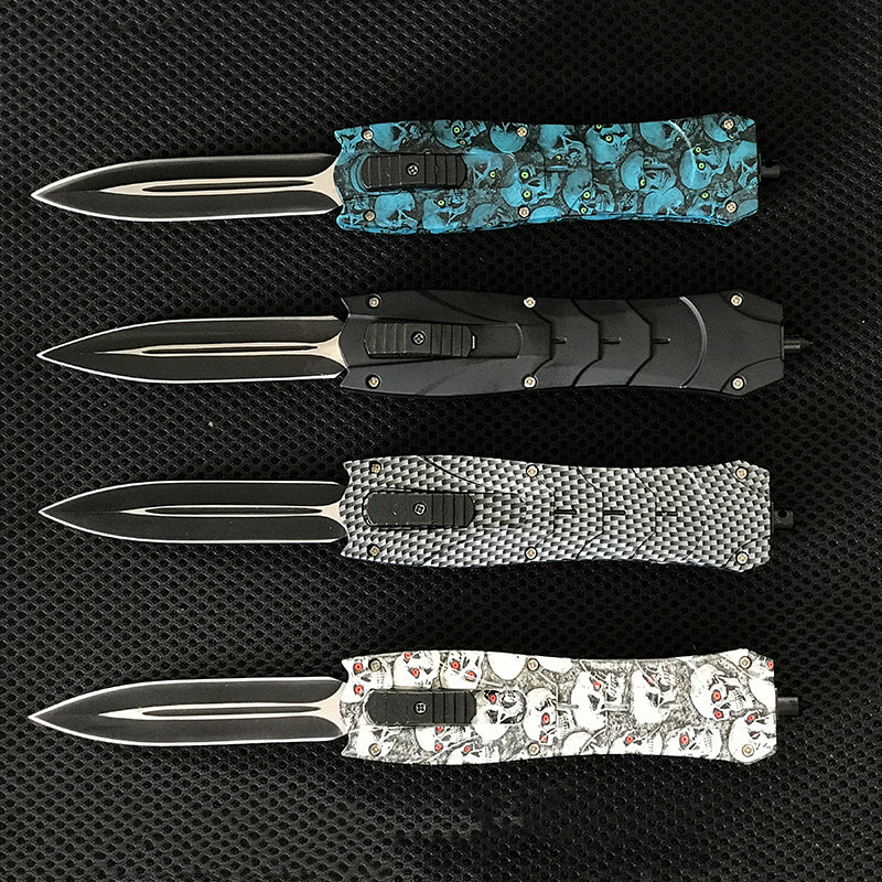 Four backpack EDC knives with black skull blue and gray handles in a row