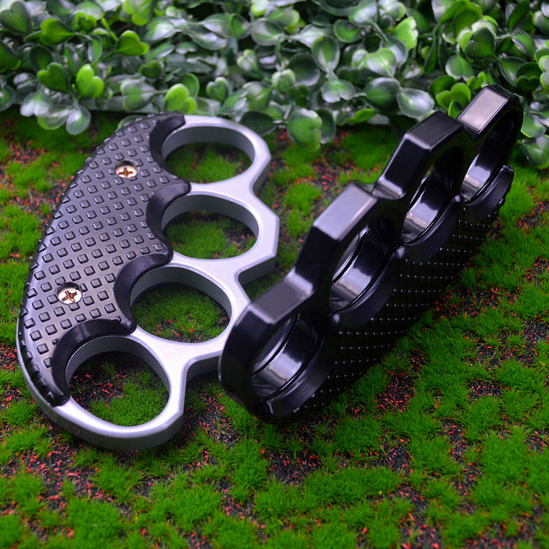Silver gray and all black knuckle dusters standing upright side by side on green moss, showing the two color options