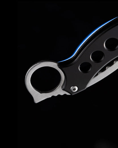 Detailed view of the finger ring and pivot area on the Black Bird folding claw knife.