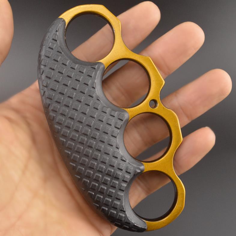 Gold-ring black-covered knuckle duster held in a palm, displaying the four-hole arc.
