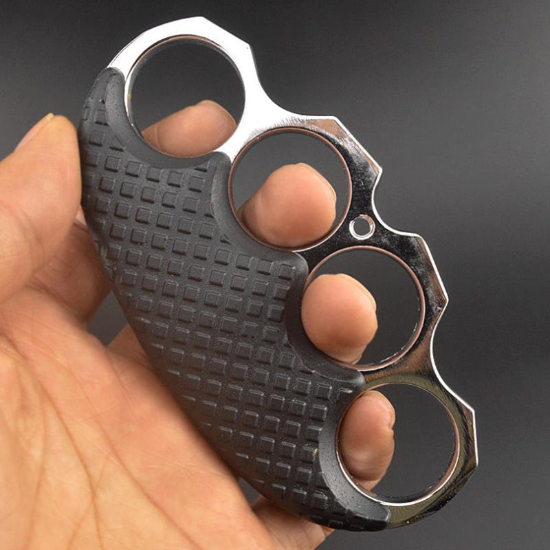 Silver-ring black-covered knuckle duster with fingers through the holes, highlighting the grip texture.