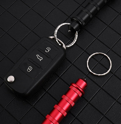 Black and Red window-break pens on a black grid — the Black one on a keyring with a car key fob, a loose Red one, and a spare keyring.