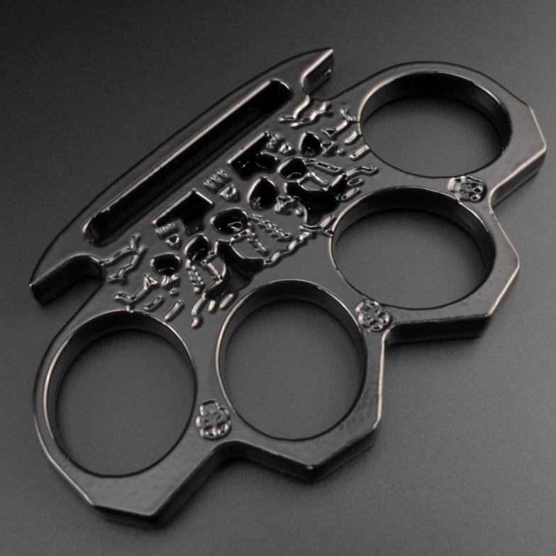 Black skeleton knuckle duster lying flat showing the elongated cut-through slot along the palm edge