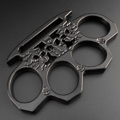 Black skeleton knuckle duster lying flat showing the elongated cut-through slot along the palm edge