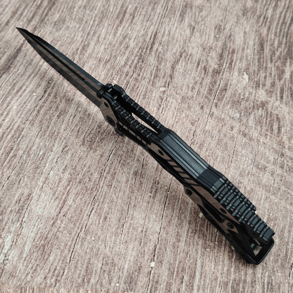Black all-steel folding knife side profile on wood surface