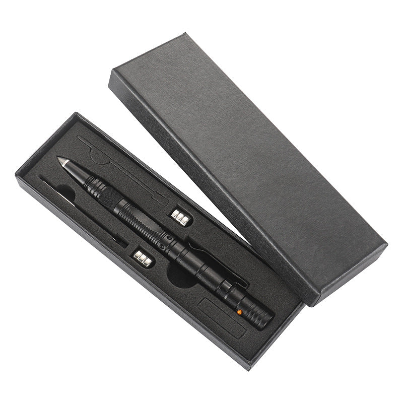 A black tactical pen presented in an open black gift box with a cut-foam insert holding the pen alongside spare AG10 button batteries and a refill, on a white background.