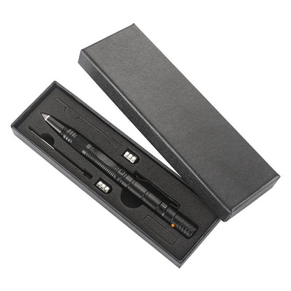 A black tactical pen presented in an open black gift box with a cut-foam insert holding the pen alongside spare AG10 button batteries and a refill, on a white background.