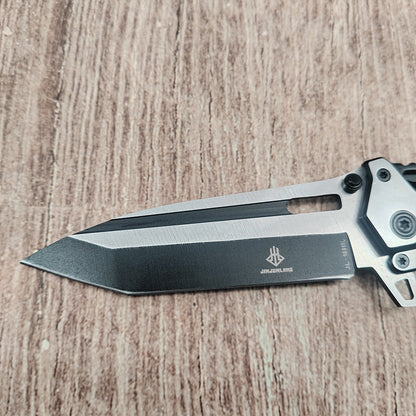 Close-up of black and silver blade with JINJUNLANG logo on wood surface