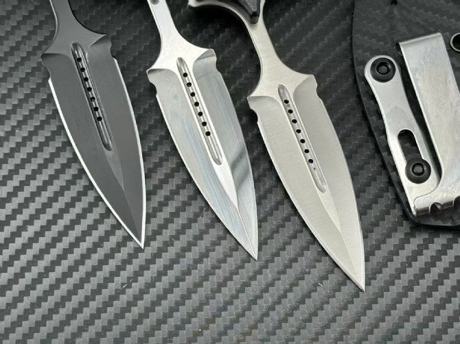 Close-up of three push dagger blade tips showing machined slots on carbon fiber background