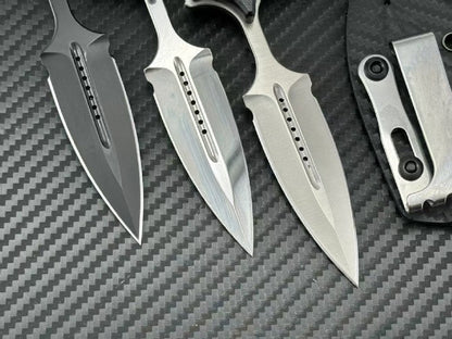 Close-up of three push dagger blade tips showing machined slots on carbon fiber background
