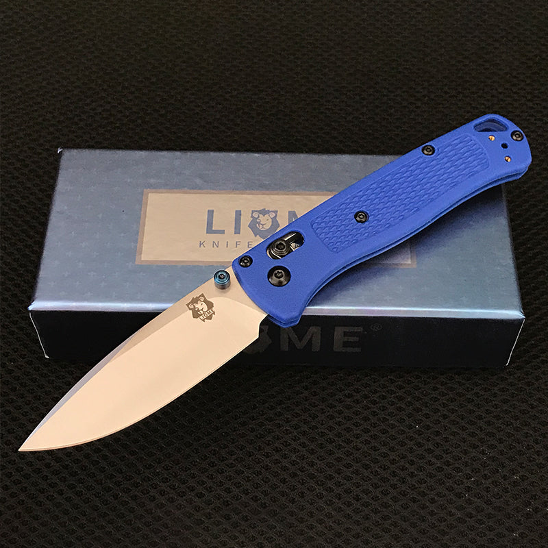 Blue handled folding knife with polished silver drop-point blade open on top of a Liome branded box
